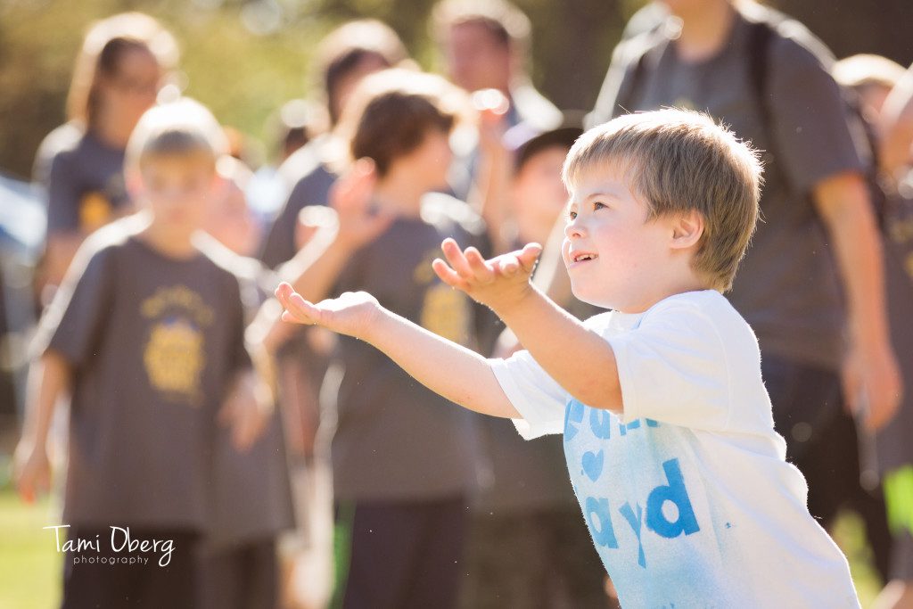 little boy reaching toward the sky