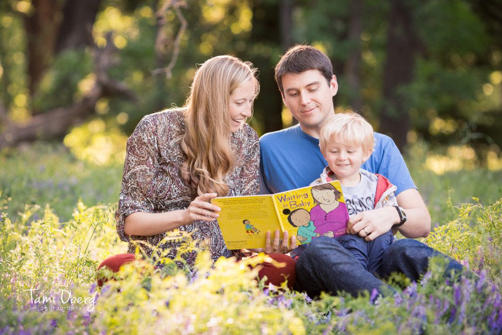 family reading a book about a baby on the way
