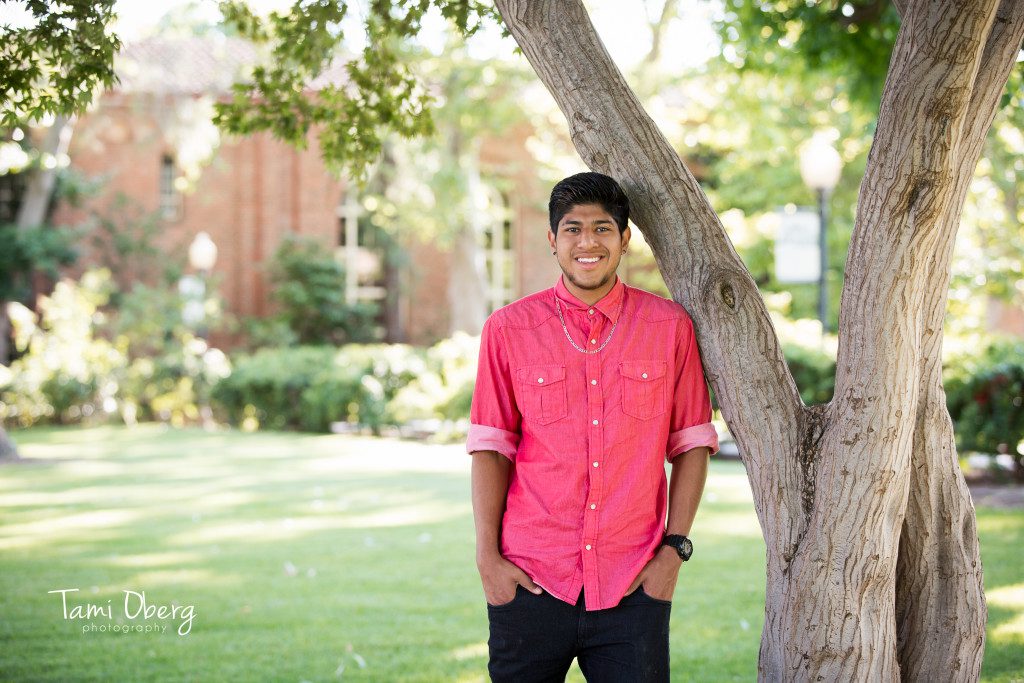 casual senior portrait leaning against a tree