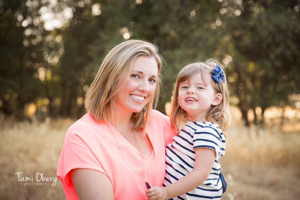mother holding her little girl in a striped shirt