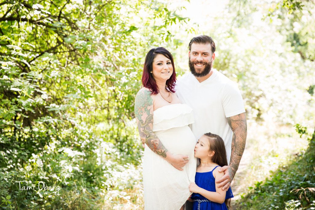 expecting family with big sister kissing belly