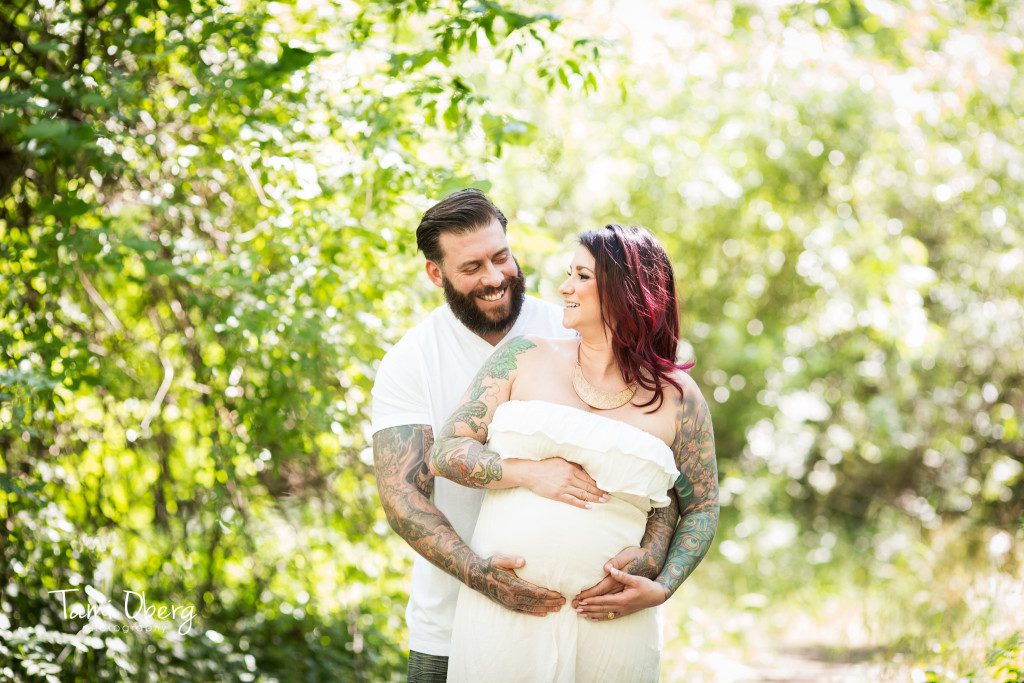 maternity couple smiling at each other