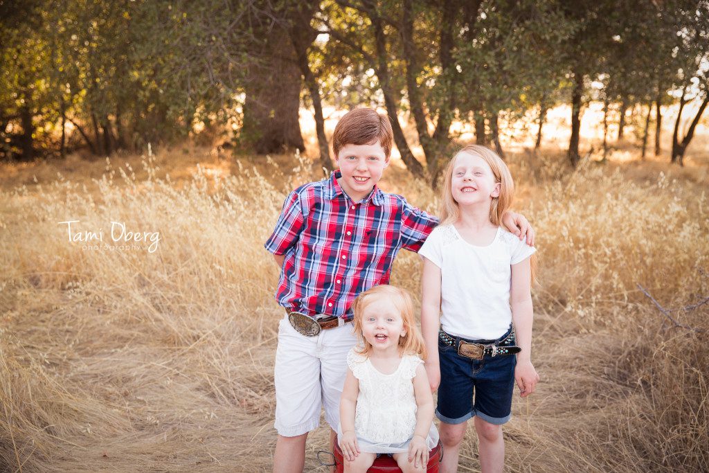 three red headed children in a field
