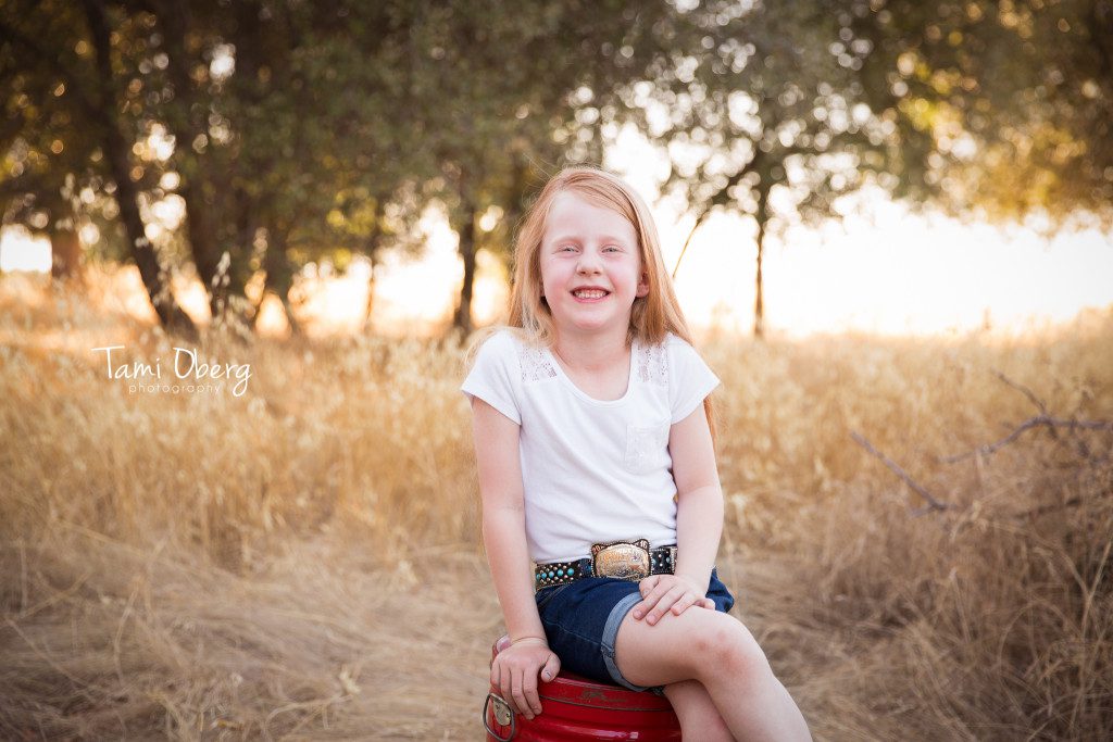 six year old girl smiling on a red bucket