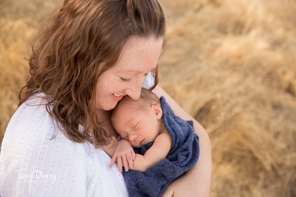 newborn with his mom in a field