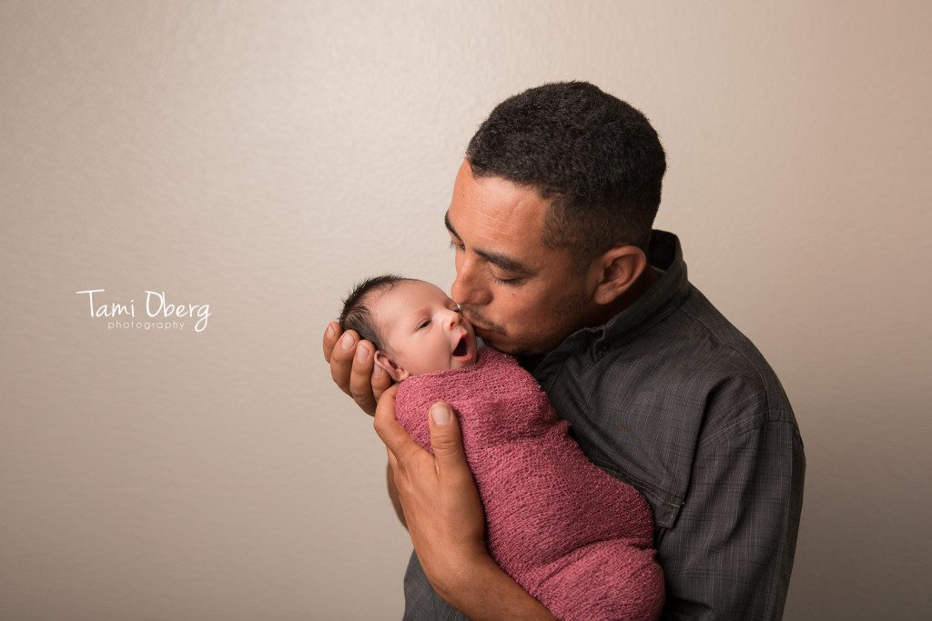 new dad kissing daughter on cheek