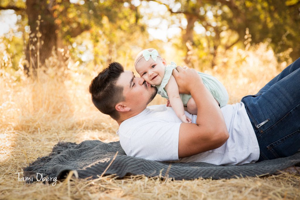 picture of new dad kissing his daughter on the cheek
