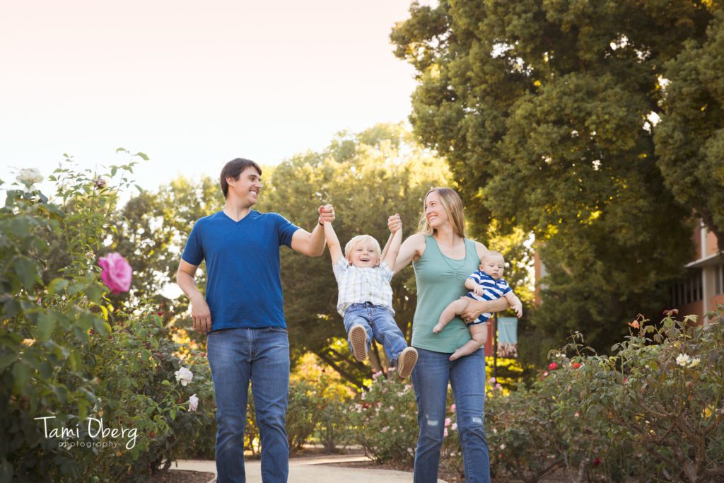 family photo swinging two year old and holding 3 month old