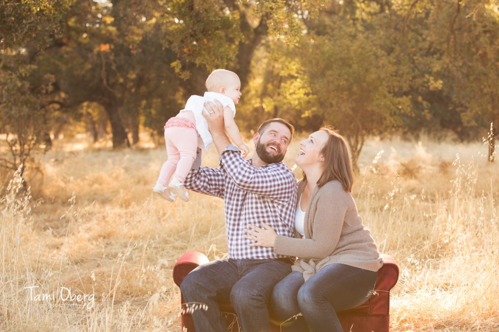 dad lifting baby girl up over his head