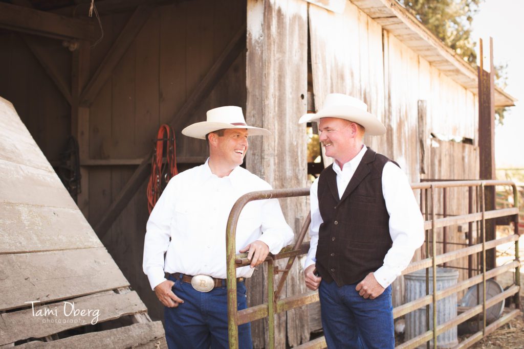 groom and best man leaning on a fence