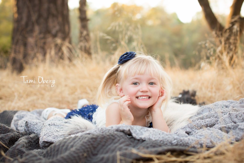 toddler lying on her tummy with her head in her hands