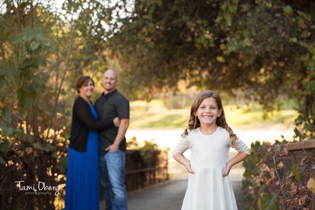 6 year old with parents in the background on a bridge