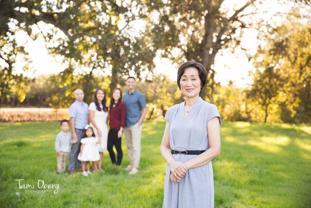 portrait of a grandmother with her family in the background