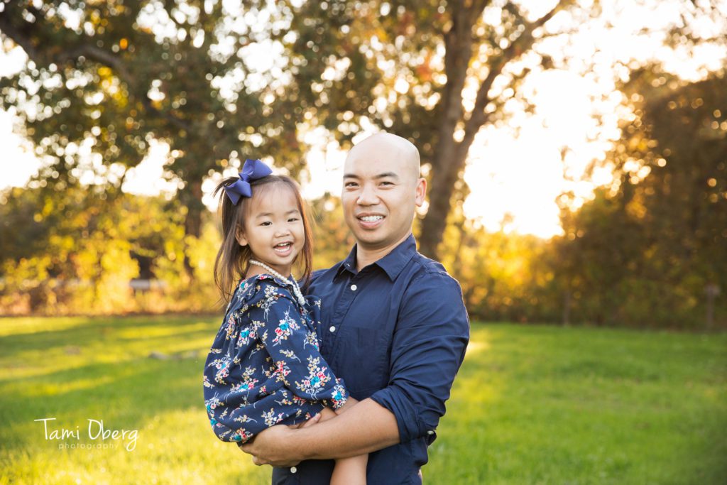 father holding his daughter with a blue ribbon in her hair