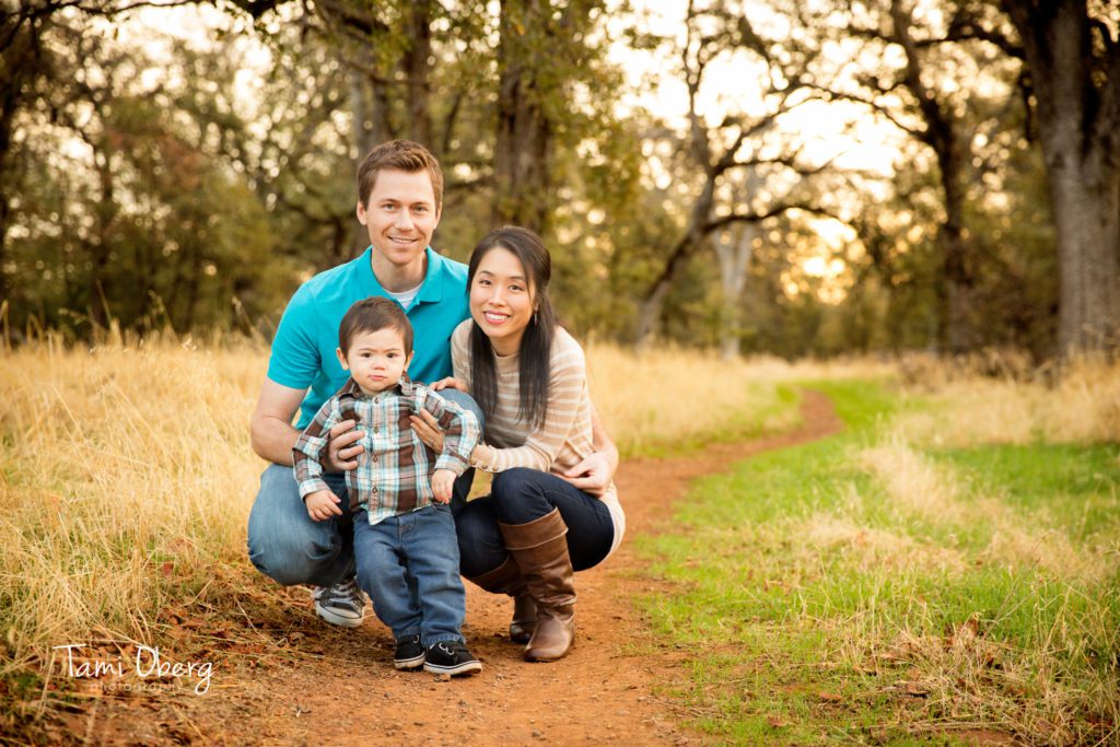 family kneeling on a path