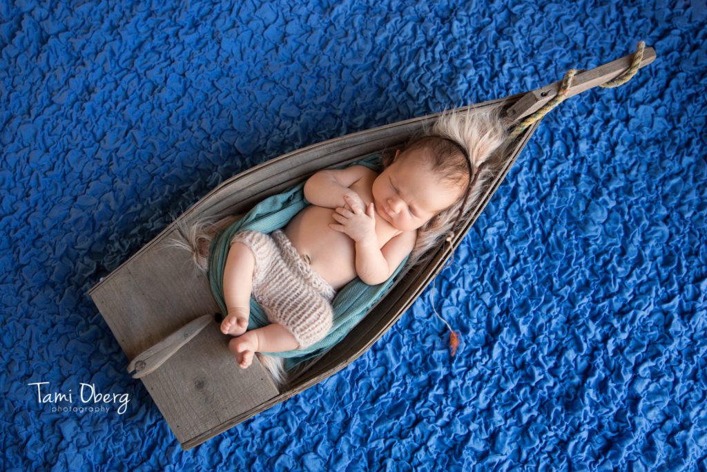 baby boy in a wooden boat